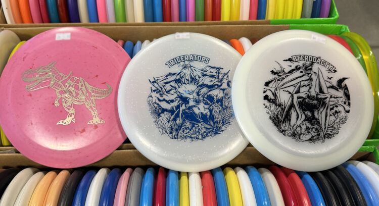 Picture showing Dino Discs, one of the fastest growing disc golf brands.