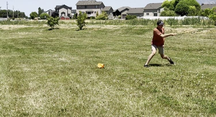 Disc golfer using a Hyzerline disc golf trainer