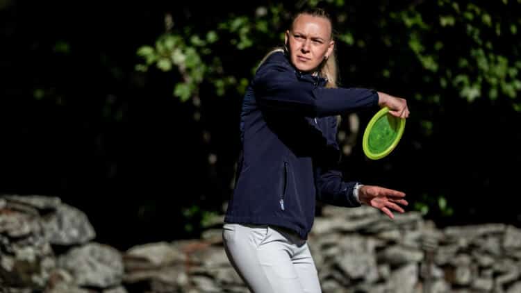 An FPO professional disc golfer throwing a disc