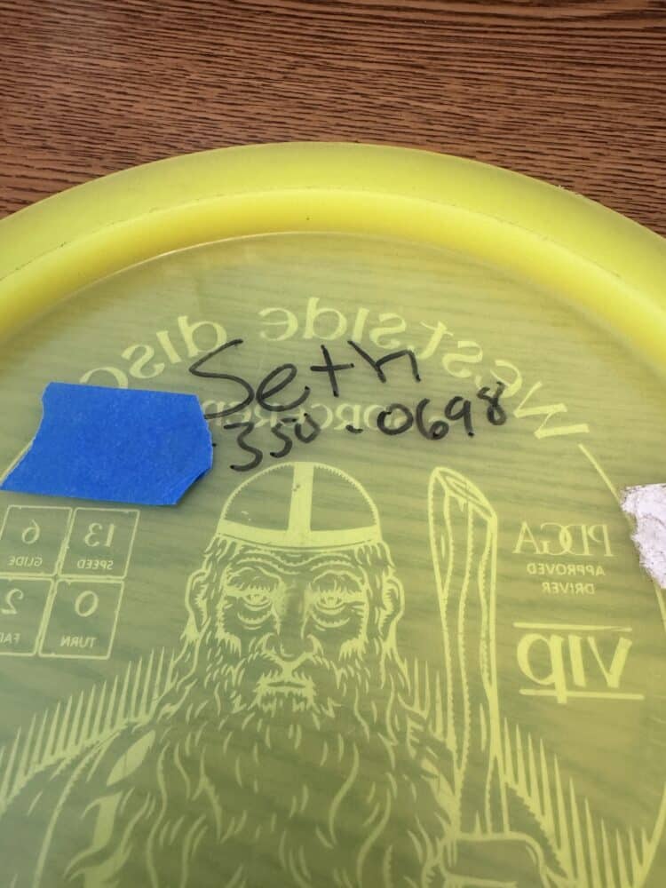 A Disc Golf Disc with a phone number written on it