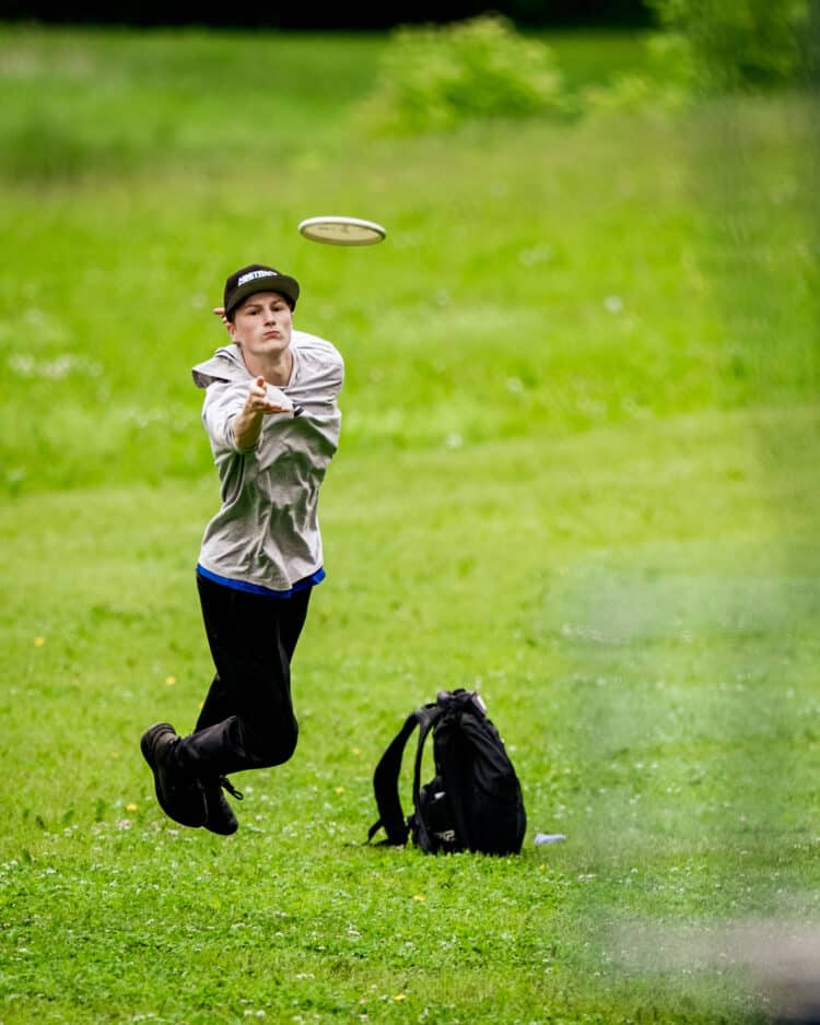 A disc golfer using a jump putt