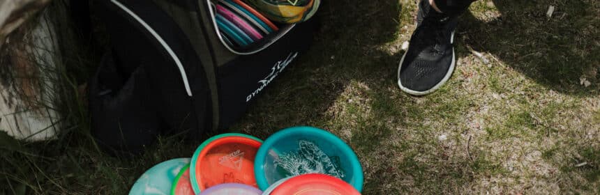 a pile of discs and a disc golf bag